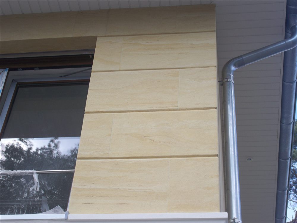 Detail einer Fassade mit großformatigen Sandsteinbahnen am Einfamilienhaus