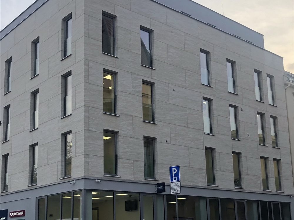 Mehrgeschossiges Gebäude mit großformatigen Fassadenplatten in hellem Stein